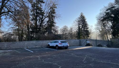 a white car parked in a parking lot at Hostellerie Au rendez-vous des amis in Chaumont