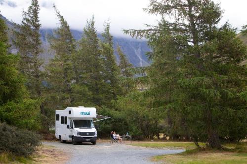a truck parked on a dirt road next to trees at Glentanner Park Centre in Glentanner
