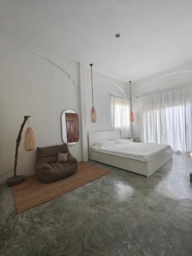 ein weißes Schlafzimmer mit einem Bett und einer Couch in der Unterkunft Island Serenity Villa in Hinkong