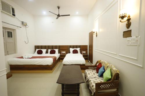 a hotel room with two beds and a couch at Bhawani Homes in Varanasi