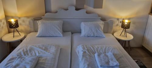 two white beds in a room with two lamps at Mountain view apartments in Bad Mitterndorf