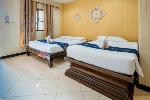 a bedroom with two beds with towels on them at Kasalong Resort and Spa Pattaya in Pattaya Central