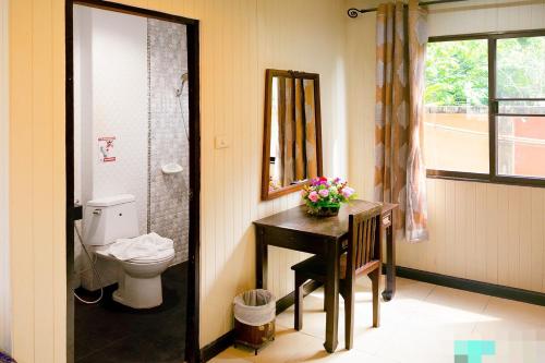 a bathroom with a sink and a toilet and a mirror at Kasalong Resort and Spa Pattaya in Pattaya Central