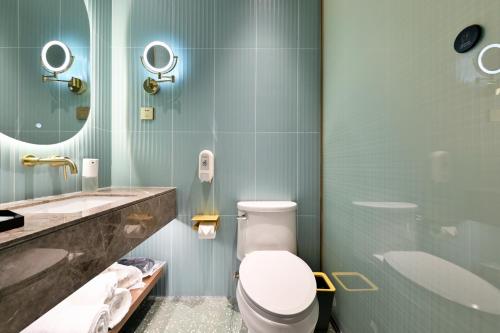 a bathroom with a toilet and a sink at Color and Light Hotel Beijing International Trade Shop in Beijing