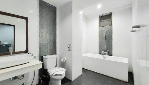 a bathroom with a sink and a toilet and a bath tub at Kasalong Resort and Spa Pattaya in Pattaya Central