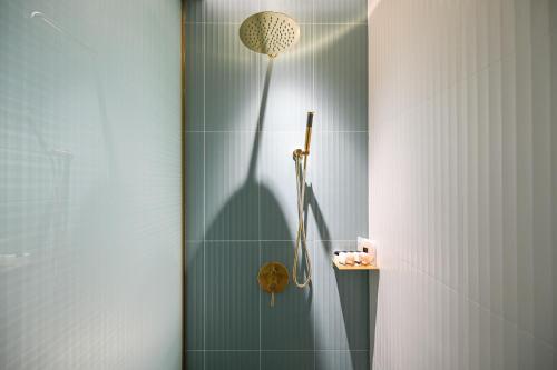 a shower with a shower head in a bathroom at Color and Light Hotel Beijing International Trade Shop in Beijing