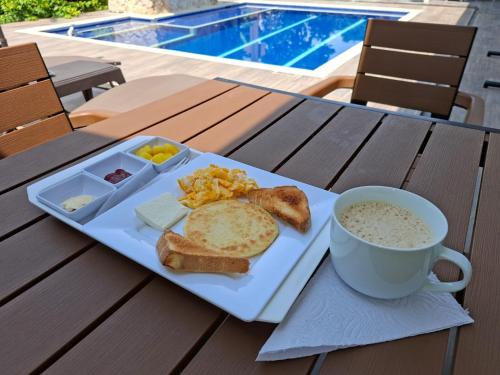 a plate of breakfast food with a cup of coffee and toast at Akoya Meraki Casa Hotel in El Silencio