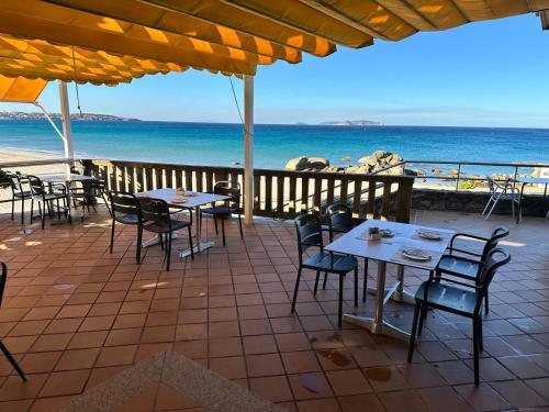 a patio with tables and chairs and the ocean at Hotel Samar in A Lanzada