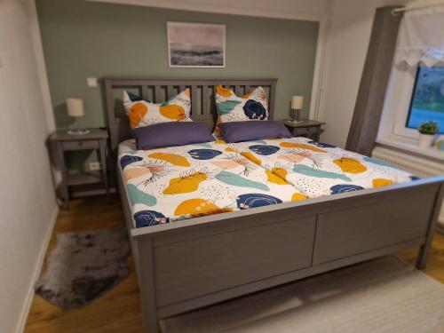 a bedroom with a bed with a comforter and pillows at Gemütliche Ferienwohnung unter Reet in Ahrenshöft