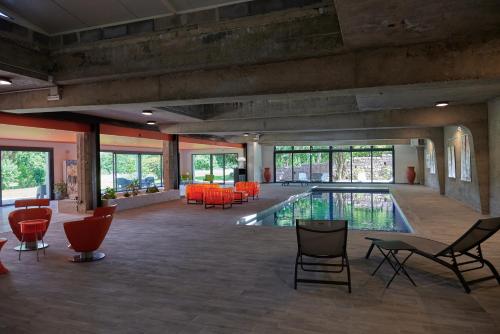 a pool in a building with chairs and tables at 2 bedroom Gîte-Cottage- Chateau de Charmeil in Charmeil