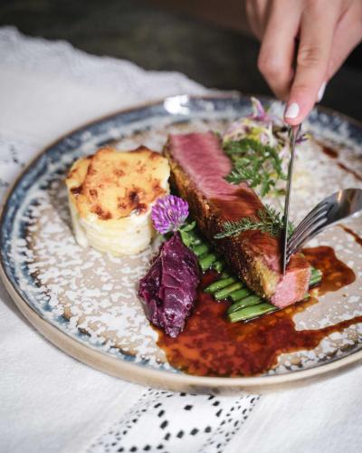 a plate of food with meat and vegetables on a table at Farmhotel Moosmair in Campo Tures