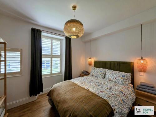 a bedroom with a bed and a large window at High Street Stay - Oban in Oban