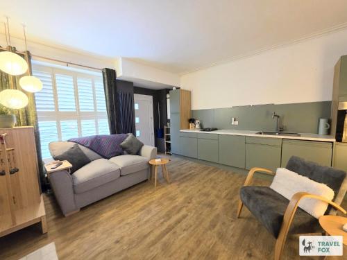 a living room with a couch and a kitchen at High Street Stay - Oban in Oban