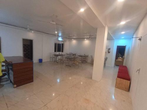 Una habitación grande con una mesa y sillas. en New Hotel AMR Grand, en Port Blair