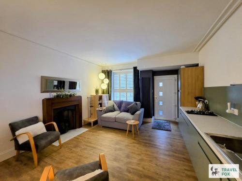 a kitchen and living room with a couch and a table at High Street Stay - Oban in Oban