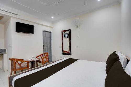 a bedroom with a bed and a tv on the wall at Jagdamba Homestay in Greater Noida