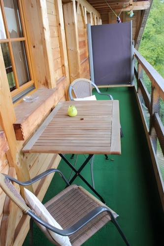 a picnic table and a chair on a porch at Sigmundenhof Schonach in Schonach