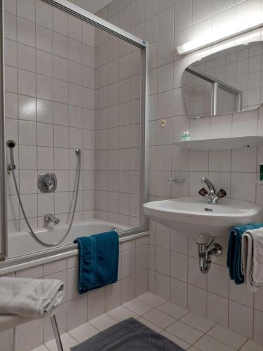Un baño blanco con lavabo y ducha. en Mehlerhof, en Tux