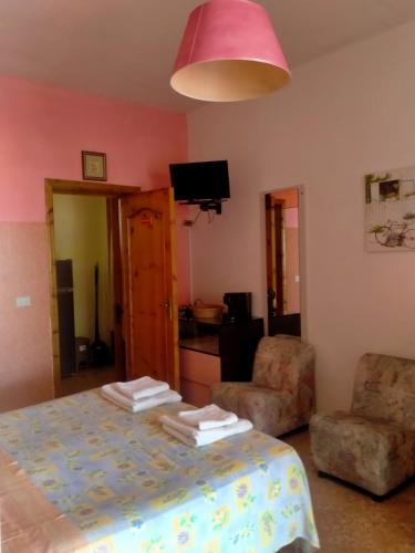 a room with a bed and a chair and a pink lamp at Villa Itaca in Sant'Isidoro