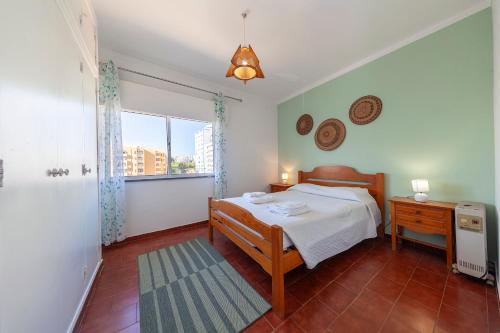 um pequeno quarto com uma cama e uma janela em Praia da Rocha Beach Step em Portimão