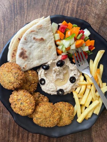 a plate of food with chicken nuggets and french fries at Wabi Sabi Hostel in Kasol