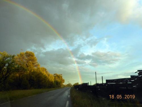 a rainbow in the sky over a road at Gite chez mamiyo gallargues le montueux in Gallargues-Le-Montueux