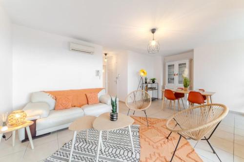 a living room with a couch and tables and chairs at l'Escale du Port - 4 Étoiles - Vue Mer - Parking in Palavas-les-Flots