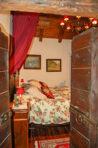 a bedroom with a bed and a table with a lamp at Chalet La Baita in Baceno