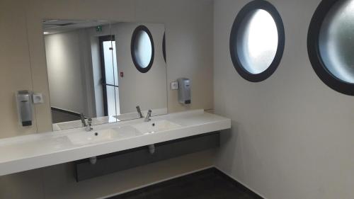 un bagno con due lavandini e due specchi di Sailboat for sea ride or instructor class a Le Grau-du-Roi