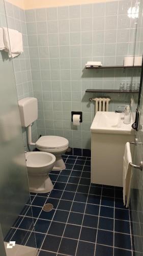a bathroom with two toilets and a sink at Hotel Conchiglia in Montecatini Terme