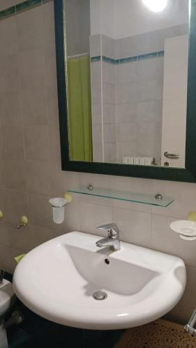 a white sink in a bathroom with a mirror at DiMore Apartments - Salento Low Cost in Lizzanello