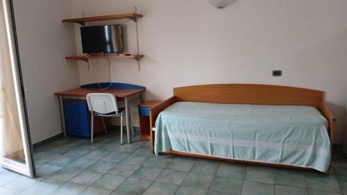 a bedroom with a bed and a desk and a television at DiMore Apartments - Salento Low Cost in Lizzanello