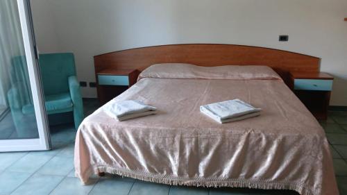 a bedroom with a bed with two towels on it at DiMore Apartments - Salento Low Cost in Lizzanello