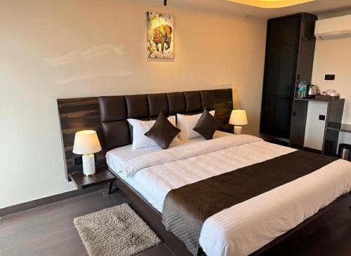 a bedroom with a large bed and two lamps at Hotel Pixel House in Hubli