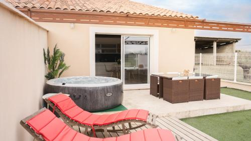 a patio with a hot tub and two red chairs at Pissenlit Une Prairie en Provence in Arles