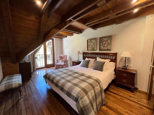 a bedroom with a large bed in a room with wooden floors at Luxury Familiar Baqueira in Naut Aran