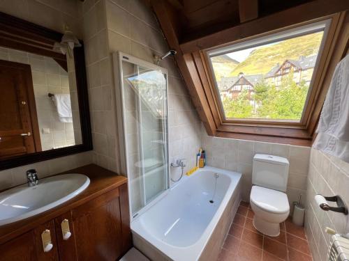 Un baño con bañera, inodoro y lavabo. en Luxury Familiar Baqueira, en Naut Aran (Alto Arán)