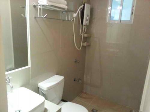 a bathroom with a white toilet and a shower at Tans Guesthouse in Boracay