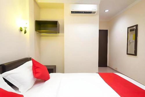 a bedroom with a white bed with red pillows at T P Hotel in Sitiawan
