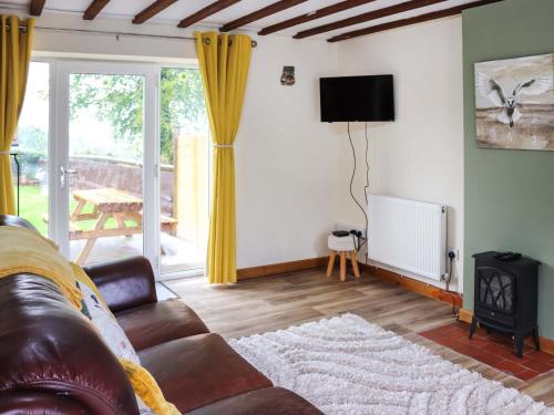 a living room with a couch and a television at Cothi Cottage - Uk49588 in Llansawel