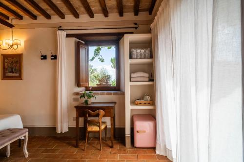 a room with a desk and a window and a table at Agriturismo Sole in Trequanda