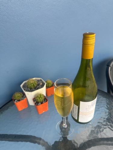 a bottle of wine and a glass on a table at บ้านเขากอดโฮมสเตย์ ปากช่อง in Ban Khlong Yang