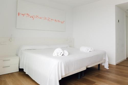 a bedroom with a white bed with two towels on it at Hotel Moon Dreams Paraiso - Adults Recommended in Es Cana