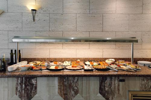 a buffet with many plates of food on a counter at Hotel Moon Dreams Paraiso - Adults Recommended in Es Cana