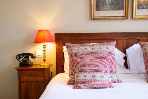 a bedroom with a bed with a lamp and pillows at Le Clair de la Plume - Teritoria in Grignan