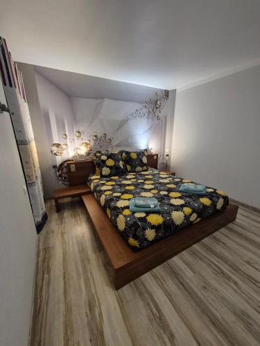 a bedroom with a large bed with a floral bedspread at la Demeure Ferralaise in Ferrals-lès-Corbières