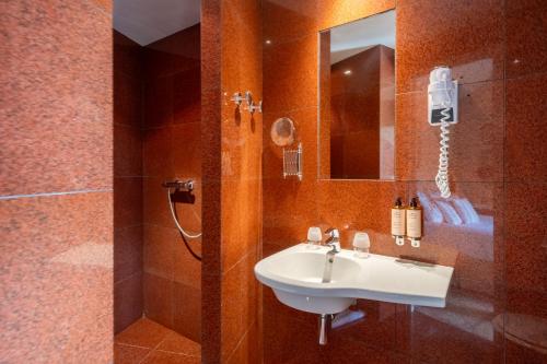 a bathroom with a sink and a shower with a mirror at Le Clair de la Plume - Teritoria in Grignan