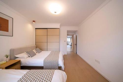 a hotel room with two beds and a hallway at Book and Bed-People's Square in Shanghai