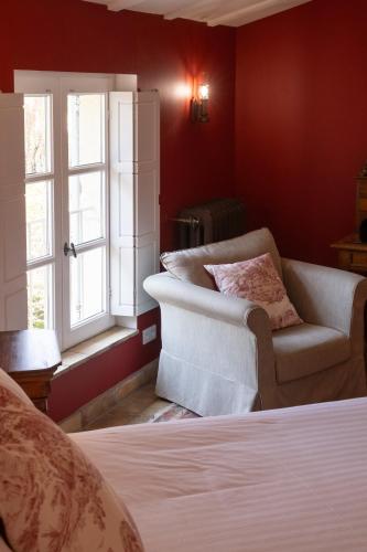 a bedroom with a bed and a chair and a window at Le Clair de la Plume - Teritoria in Grignan