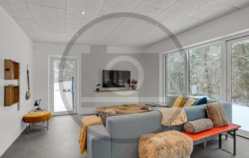 Una sala de estar con un sofá azul y una mesa. en 4 Bedroom Awesome Home In Thyholm, en Oddesund Syd